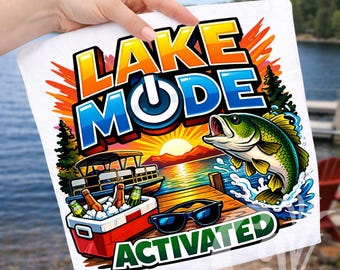 May include: White graphic tee with the words "LAKE MODE ACTIVATED". The design features a sunset over a lake, a pontoon boat, a cooler with drinks, sunglasses, and a leaping fish.