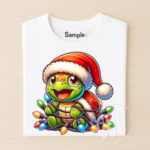 May include: White t-shirt featuring a cartoon turtle wearing a Santa hat and wrapped in colorful Christmas lights. The turtle has a green head and shell, with a red and brown shell. The shirt has the word "Sample" printed on it.