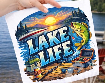 May include: White t-shirt with a colorful "Lake Life" graphic. The design features a sunset over a lake, a boat, a fishing scene with a fish, and fishing gear. A can of beer is also included in the design.