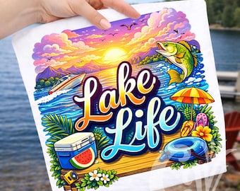May include: White towel with a colorful "Lake Life" design. The illustration features a sunset over a lake, a fishing scene, a boat, and beach accessories. A cooler with a watermelon slice, a yellow camera, and a blue inner tube are also shown.