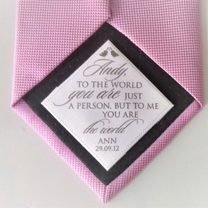 May include: A pink tie with a white tag that says "Andy, to the world you are just a person, but to me you are the world ANN 29.09.12".
