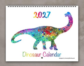 May include: A 2027 wall calendar featuring a large, long-necked dinosaur silhouette filled with a vibrant, multi-colored splatter paint pattern. The text 2027 appears above the dinosaur, and the words Dinosaur Calendar are printed below it.
