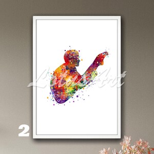 Op de afbeelding: Een ingelijste aquarelprint met een duiker in volle duik. De duiker is afgebeeld in een levendige reeks kleuren, waaronder rood, oranje, geel, groen, blauw en paars. Het kunstwerk staat tegen een witte achtergrond, met het nummer "2" linksonder.