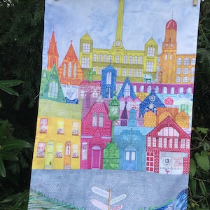 Könnte beinhalten: Eine farbenfrohe Illustration einer Stadt mit Gebäuden in verschiedenen Farbtönen von Gelb, Rot, Blau und Grün. Die Illustration enthält einen Fluss, ein Schild mit der Aufschrift "The Vale Farm" und den Text "1865" an einem der Gebäude.