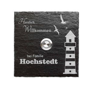 Könnte beinhalten: Schwarze Schiefer-Türklingel mit einem weißen, gravierten Leuchtturm, zwei Vögeln und dem Text "Herzlich Willkommen bei Familie Hochstedt".