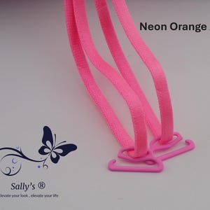 May include: Neon pink bra straps with matching plastic hooks. The straps are made of a woven material. The image also includes a butterfly logo and the text "Neon Orange / Pink".