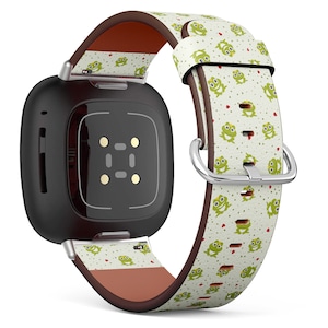 May include: A black square smartwatch with a brown leather band featuring a white and green frog pattern. The band has red hearts and green dots.