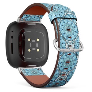 Op de afbeelding: Een zwarte smartwatch met een blauw en wit gepatroneerd leren bandje. Het bandje heeft een geometrisch ontwerp.