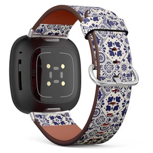 May include: A black square smartwatch with a white and blue patterned leather band. The band has a brown leather lining.