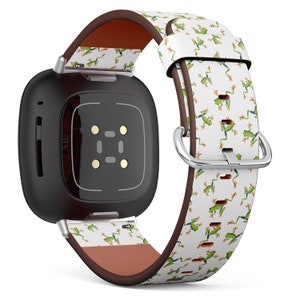 Puede incluir: Un reloj inteligente cuadrado negro con una banda de cuero de estampado de rana blanca y verde. La banda tiene un forro de cuero marrón.