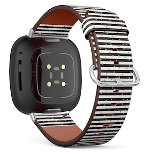 May include: Black and white striped watch band with gold polka dots. The band has a brown leather lining and a silver buckle.