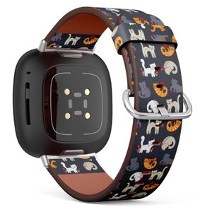 May include: A black smartwatch with a brown leather band featuring a colorful cat print. The watch face has a digital display with four small white dots.