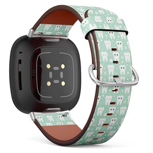 Puede incluir: Un reloj inteligente negro con una correa de cuero de color verde menta y blanco con un diseño repetitivo de dientes de dibujos animados. La correa tiene un forro de cuero marrón.