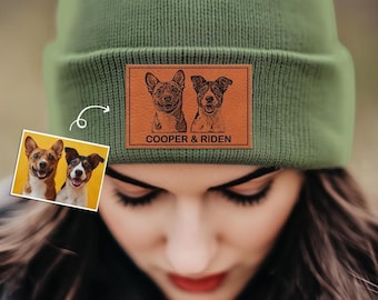 May include: A green knitted beanie with a brown leather patch featuring two dog portraits and the text "COOPER & RIDEN".