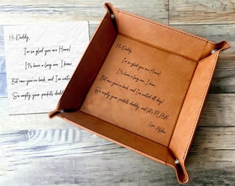 May include: A brown leather valet tray with a handwritten note inside that reads "Hi Daddy. I'm so glad you are Homel It's been a long one, I know. But now you're back, and I've waited all day! So empty your pockets daddy, and let's PLAY! Love, Alder"