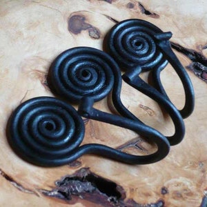 Può includere: Tre ganci a spirale in metallo nero con forma arrotondata. I ganci sono disposti a forma di triangolo.