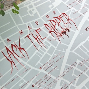 May include: A map of London's Whitechapel district, highlighting the locations of Jack the Ripper's victims. The map is printed on white paper with red text and markings. The title "A Map of Jack the Ripper" is written in a bloody red font.