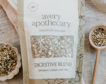 May include: A package of "Digestive Blend" organic loose leaf tea from Avery Apothecary. The package is beige with a clear window showing the tea blend. A small dish and a wooden spoon, both filled with tea, are also visible.