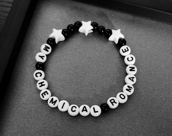 May include: A black and white beaded bracelet with the words "My Chemical Romance" spelled out in black letters on white beads. The bracelet is accented with three white star-shaped beads.