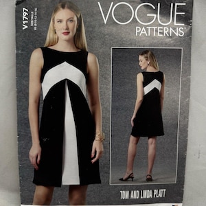 May include: A Vogue Patterns sewing pattern envelope V1797 for a sleeveless dress. The front shows a black dress with a white chevron-shaped front panel. The back view shows a black dress with a white chevron panel. Text includes VOGUE PATTERNS.