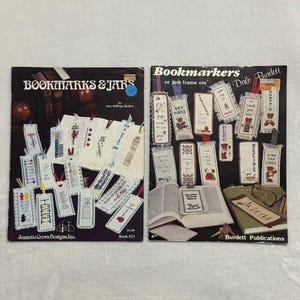 May include: Two instructional craft booklets titled Bookmarks & Jars by Jeanette Crews Designs and Bookmarkers or just frame em by Dale Burdett. Both covers feature color photographs of various cross-stitch bookmark designs with text.