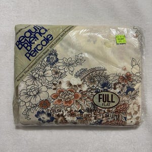 May include: A packaged full flat sheet set with a floral pattern in shades of brown, blue, and orange on a cream background. The package is labeled "Beauty Blend Percale" and includes the dimensions: 81 x 96 inches.
