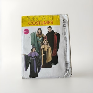 May include: A McCall's Costumes sewing pattern envelope M6421 for adult costumes. The front features illustrations of people wearing hooded robes and capes in black, green, gold, and purple. The text includes McCall's Costumes, Easy, and M6421.