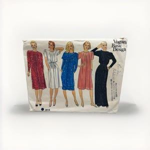 Peut inclure: Une enveloppe de patron de couture Vogue Basic Design vintage. Le patron présente des illustrations de cinq robes différentes en rouge, blanc, bleu, rose et noir. L'enveloppe porte les mentions "Vogue's Basic Design" et "Linda Farrell".