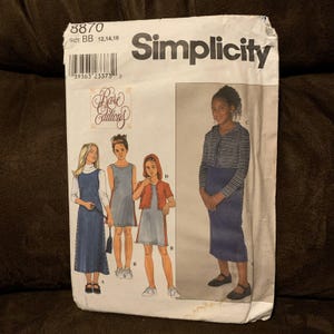May include: A Simplicity sewing pattern envelope, number 8870, size BB 12, 14, 16. The front features illustrations of four variations of a dress, including sleeveless and hooded styles, with the Rare Editions logo and a barcode printed at the top.