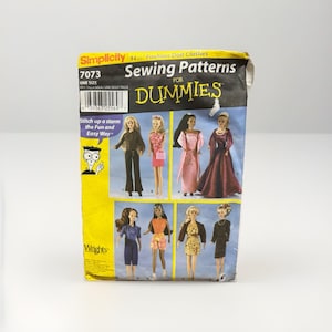 May include: A Simplicity sewing pattern for fashion doll clothes, featuring the text "Sewing Patterns for Dummies." The pattern includes images of various doll outfits. The package is yellow and black.
