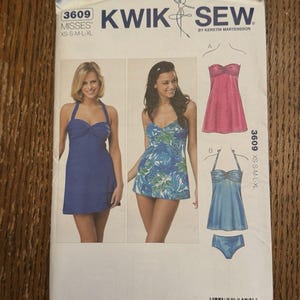 May include: A Kwik Sew 3609 sewing pattern envelope for misses' sizes XS-S-M-L-XL. The front displays two photographs of halter-style swim dresses in solid blue and blue-green leaf print, alongside illustrations of two variations labeled A and B.