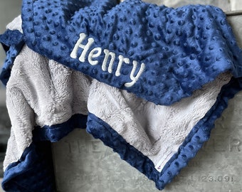 May include: A blue and gray baby blanket with the name "Henry" embroidered on it.