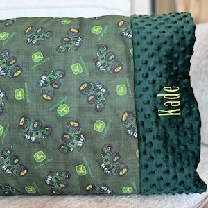May include: A green and yellow personalized pillow with a green tractor pattern and the name "Kade" embroidered on the side.