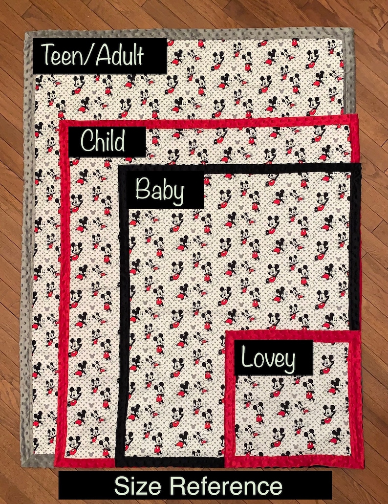 May include: Size reference for Mickey Mouse blankets in four sizes: Teen/Adult, Child, Baby, and Lovey. The blankets are white with a red and black Mickey Mouse print. The Teen/Adult blanket has a gray border, the Child blanket has a red border, the Baby blanket has a black border, and the Lovey blanket has a red border.