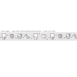 May include: 15mm washi tape in light grey with a silver foil finish. The tape features a repeating pattern of bears with different accessories, including a book, glasses, a pen, and a heart. The text "Light Grey Planning/Journaling Bears - Silver Foil (10m)" is printed on the tape.