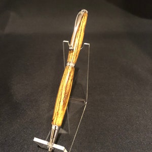 Bolígrafo hecho a mano con madera de Bocote y herrajes de rodio.