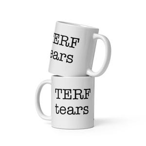 Pode incluir: Duas canecas de cerâmica branca empilhadas. A caneca superior diz "TERF tears" em letras pretas. A caneca inferior também diz "TERF tears" em letras pretas. Ambas as canecas têm uma alça branca.