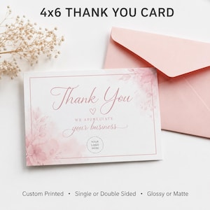 May include: A 4x6 inch thank you card with a pink floral design and the words "Thank You" in elegant script. The card includes the text "We appreciate your business" and space for a logo. A matching pink envelope is also present.
