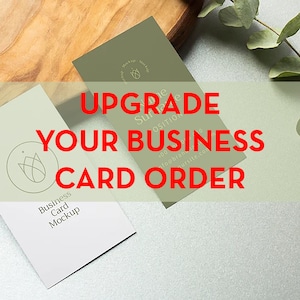 Puede incluir: Dos maquetas de tarjetas de visita sobre una superficie de madera. La tarjeta de la izquierda es blanca con un diseño floral simple y el texto "Business Card Mockup". La tarjeta de la derecha es verde con el texto "Upgrade Your Business Card Order".