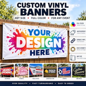 May include: A custom vinyl banner featuring a white background with a large, colorful rainbow paint splatter graphic and the text "YOUR DESIGN HERE" in bold blue letters. The banner includes brass grommets and is displayed on a wooden fence.