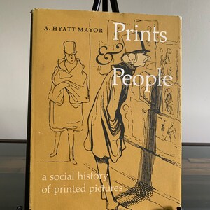 May include: A book titled "Prints & People" by A. Hyatt Mayor. The cover features a sepia-toned illustration of figures in period clothing. The subtitle reads "a social history of printed pictures."
