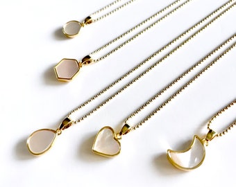 May include: Five gold necklaces with different shaped pendants made of white mother of pearl. The pendants are a circle, hexagon, teardrop, heart, and crescent moon.