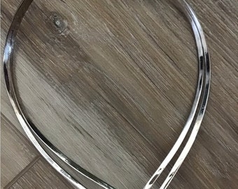 Coker vintage em prata em formato de V com pulseira combinando.