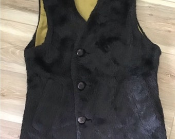 May include: A black faux fur vest with a button closure. The vest has a brown lining.