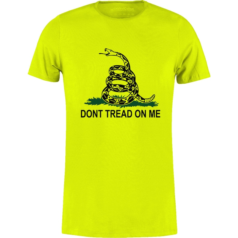Op de afbeelding: Een felgeel t-shirt met een opgerolde ratelslang in zwart en geel, boven de zwarte tekst "DONT TREAD ON ME". Het shirt heeft een ronde hals.