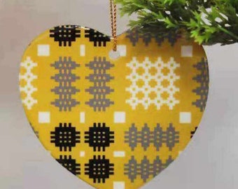 May include: A yellow heart-shaped ceramic ornament with a geometric pattern in black, white, and gray.