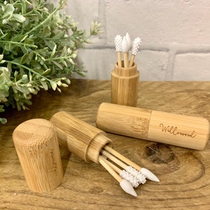 May include: Two bamboo cases with lids containing reusable cotton swabs with white silicone tips. The cases are engraved with the words "Willowood" and "Naturally".