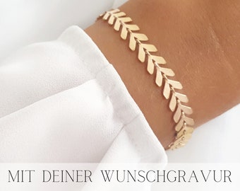 May include: Gold bracelet with a chevron pattern. The bracelet is on a person's wrist. The text "MIT DEINER WUNSCHGRAVUR" is visible at the bottom of the image.