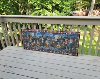 May include: A framed painting depicting a colorful scene with multiple figures in a garden setting. The painting is done in a traditional Indian style with intricate details and vibrant colors.
