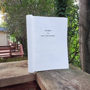 Peut inclure: Un livre blanc avec le titre "The Matrix" par Larry & Andy Wachowski.